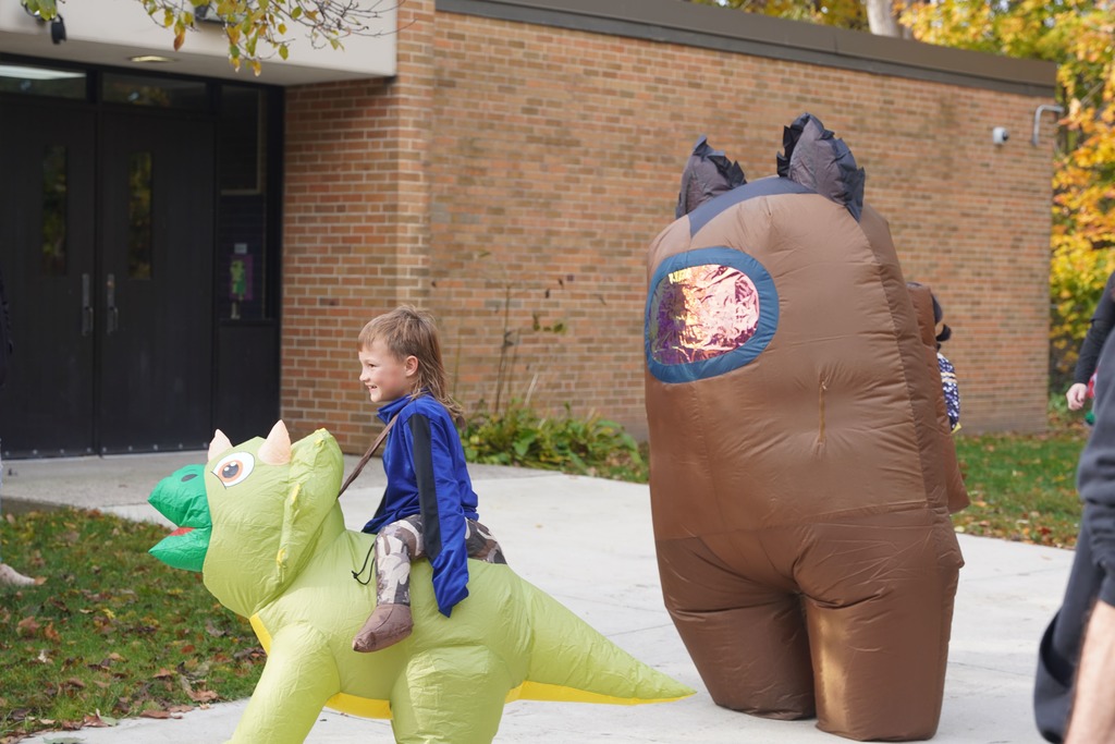 Southeastern Elementary students walking in their Halloween parade, surrounded by onlooking parents.