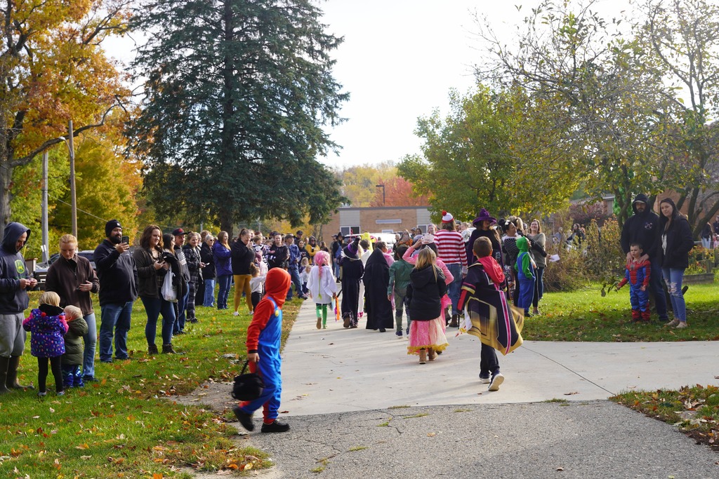 Southeastern Elementary students walking in their Halloween parade, surrounded by onlooking parents.