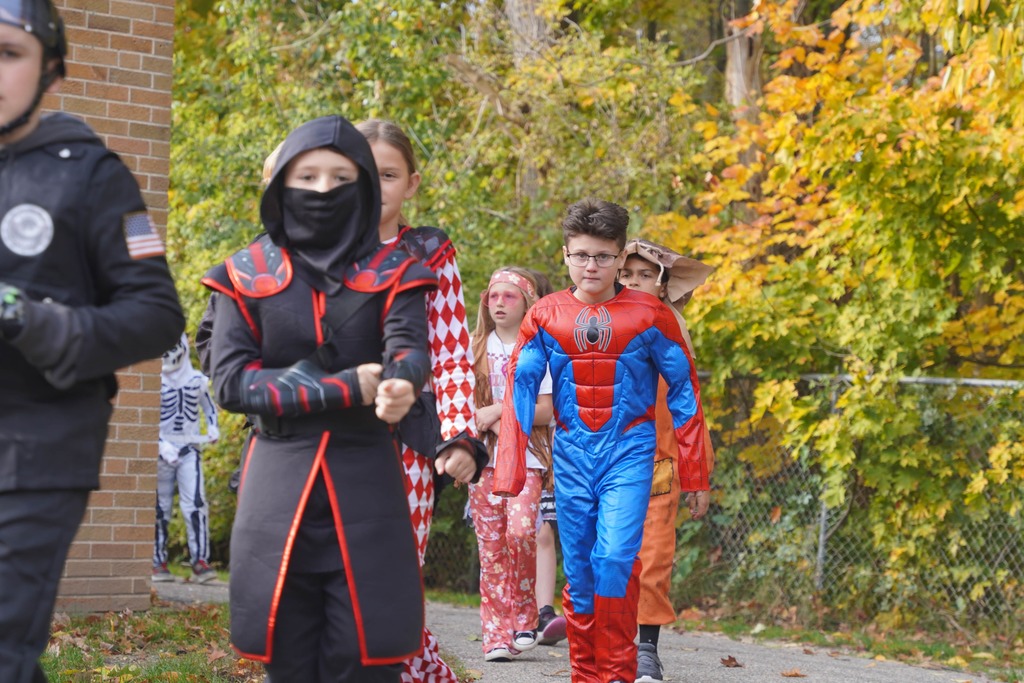 Southeastern Elementary students walking in their Halloween parade, surrounded by onlooking parents.
