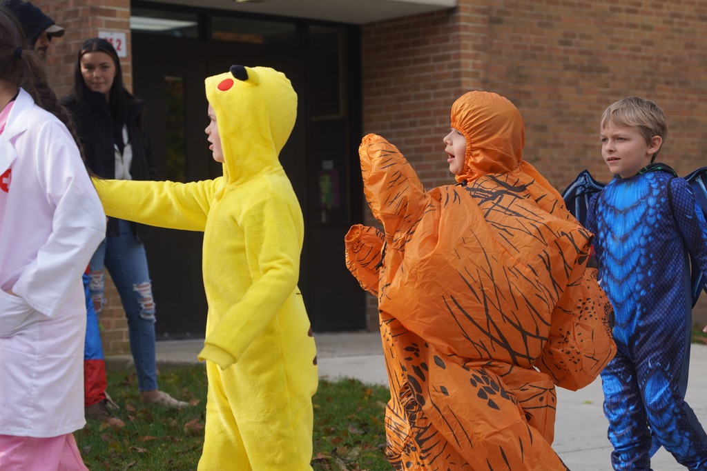 Southeastern Elementary students walking in their Halloween parade, surrounded by onlooking parents.