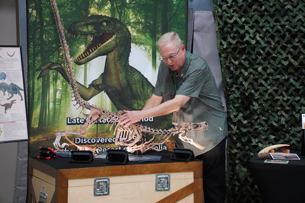 A man presents the skeleton of a dinosaur.