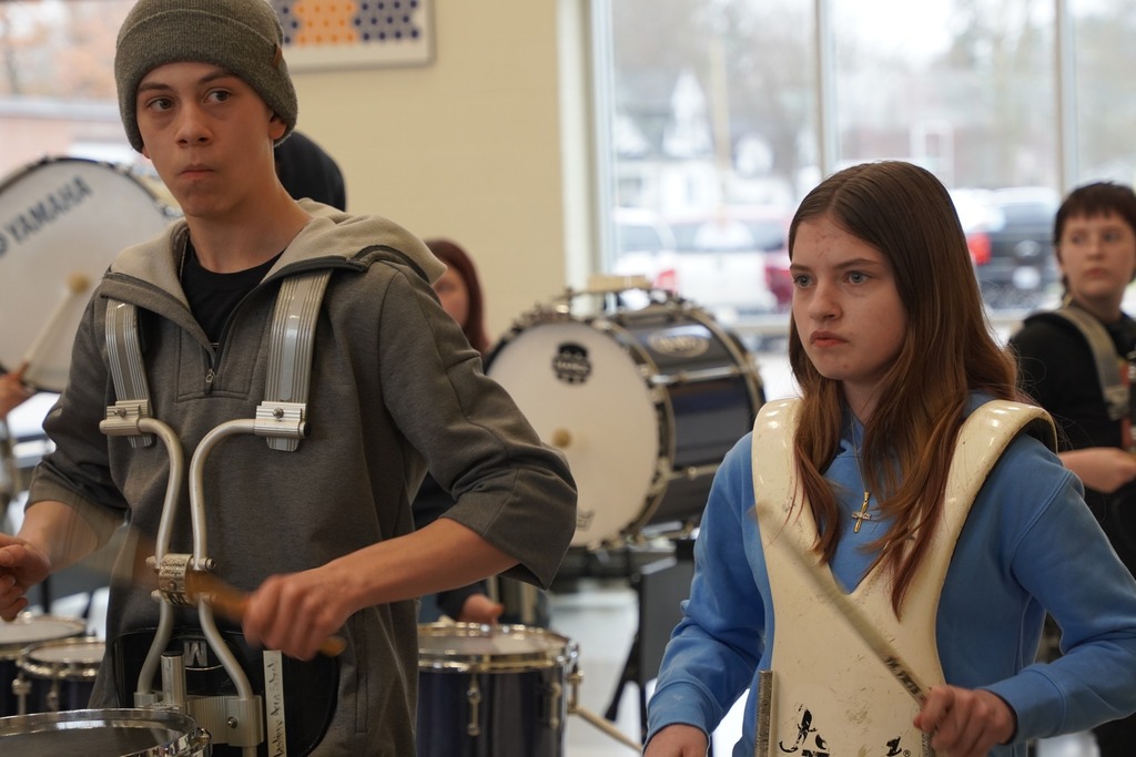 HMS drum line playing in the cafeteria as students walk out of the building for Spring Break