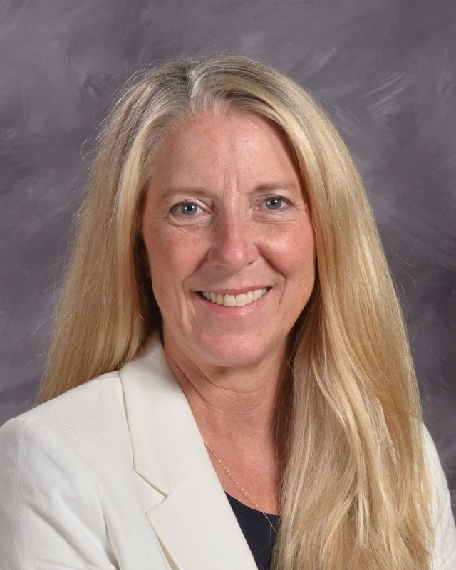 A blonde woman smiles in a portrait shot