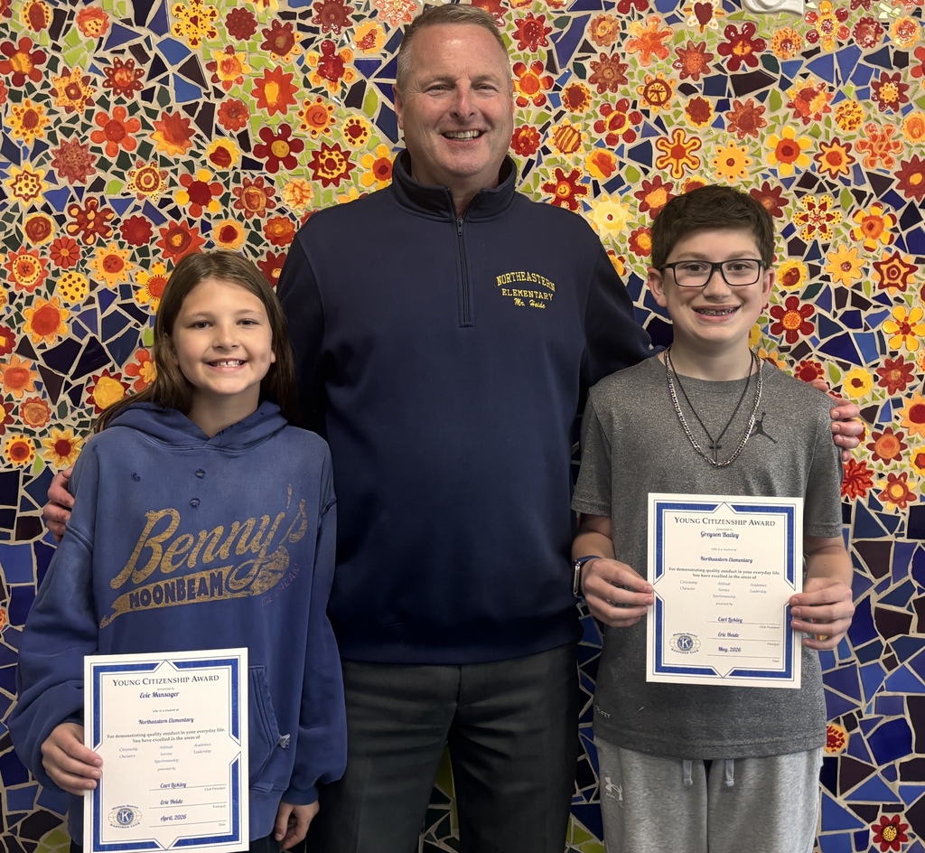 Two students stand next to an adult as they display their certificates.