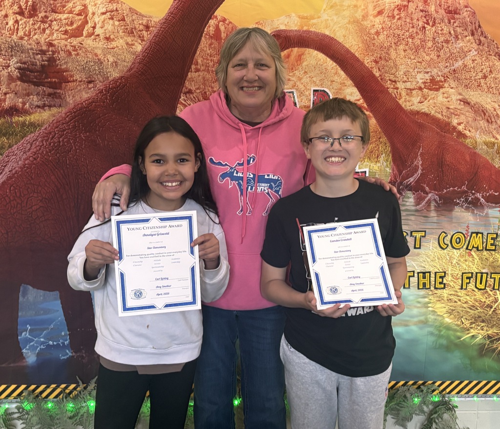 Two students stand next to an adult as they display their certificates.