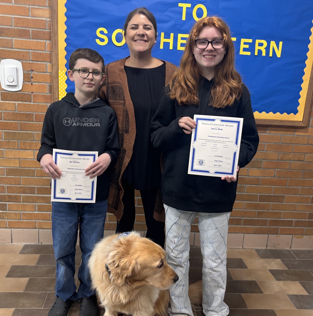 Two students stand next to an adult as they display their certificates.