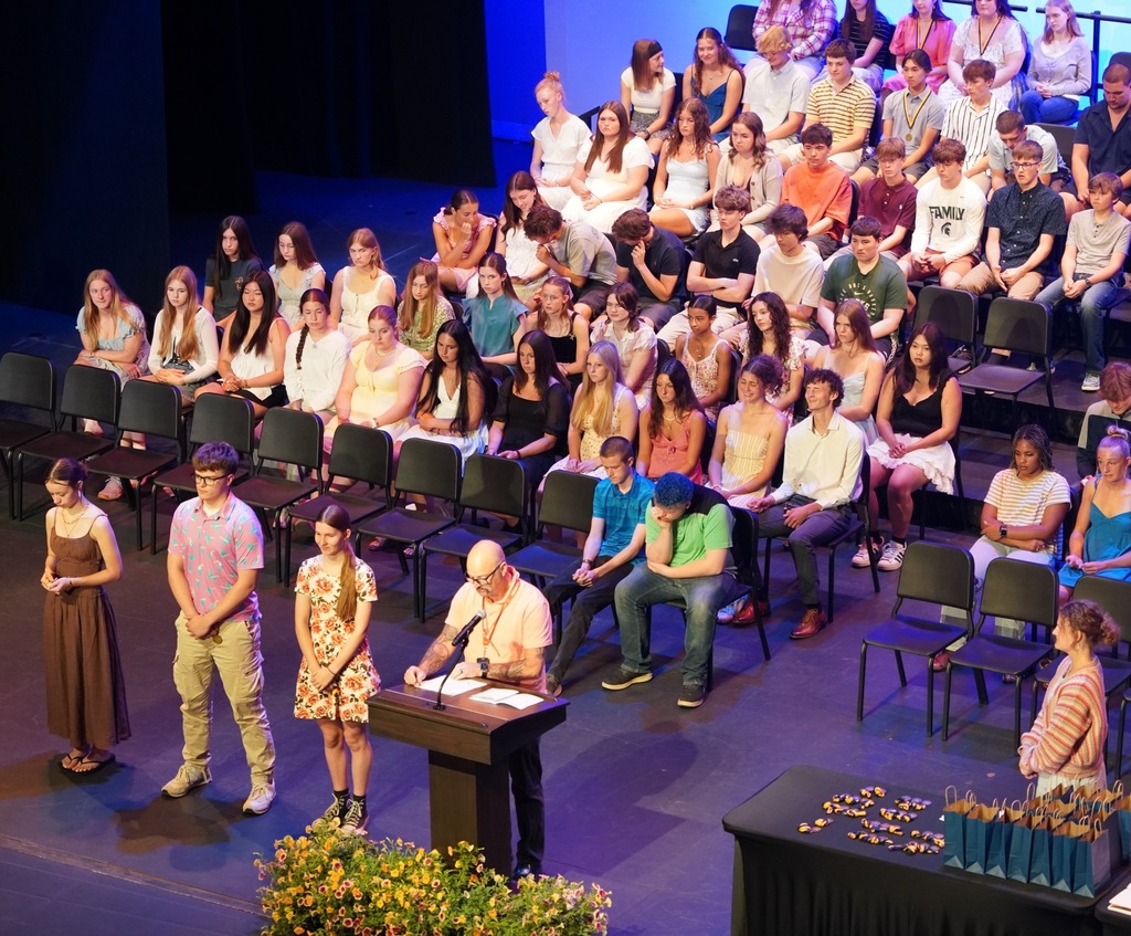 Students seated on stage and speakers present at HHS underclassmen honors night