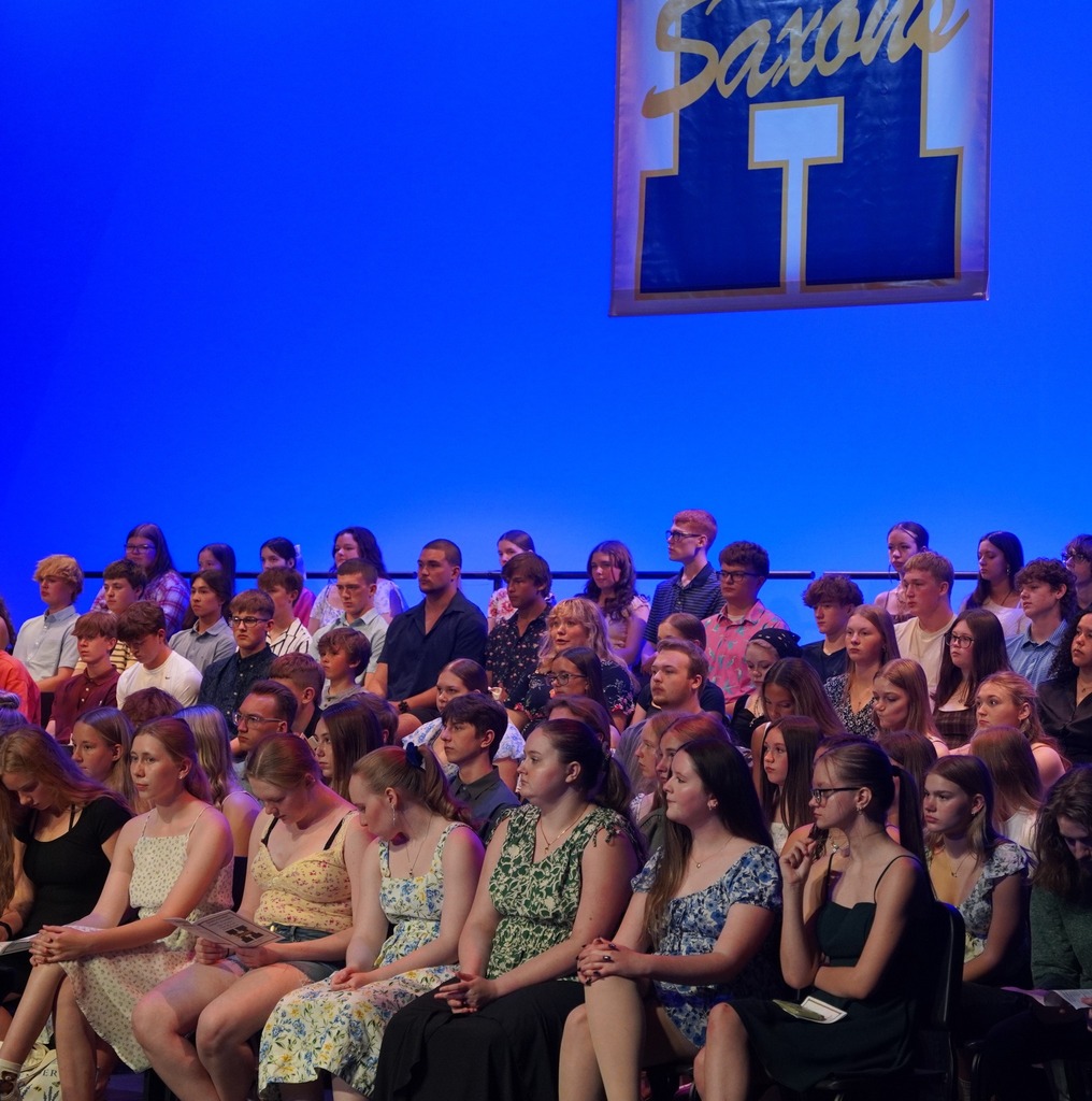 Students seated on stage and speakers present at HHS underclassmen honors night