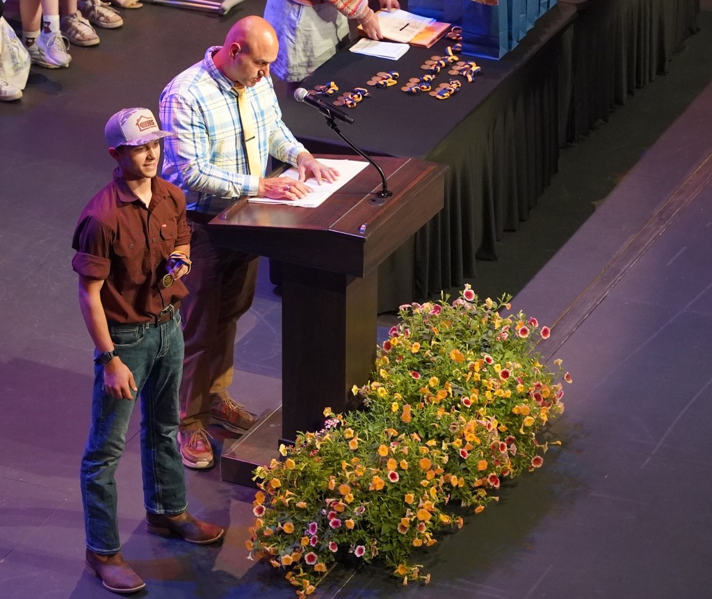 Students seated on stage and speakers present at HHS underclassmen honors night