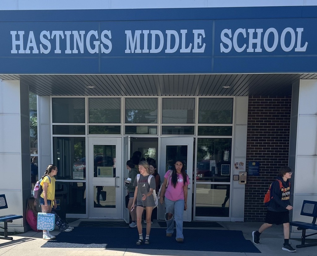 Students emerge from a door underneath and overhand that says "Hastings Middle School"