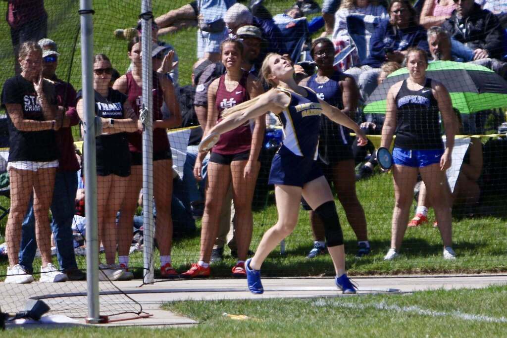 A female athlete launches a discus