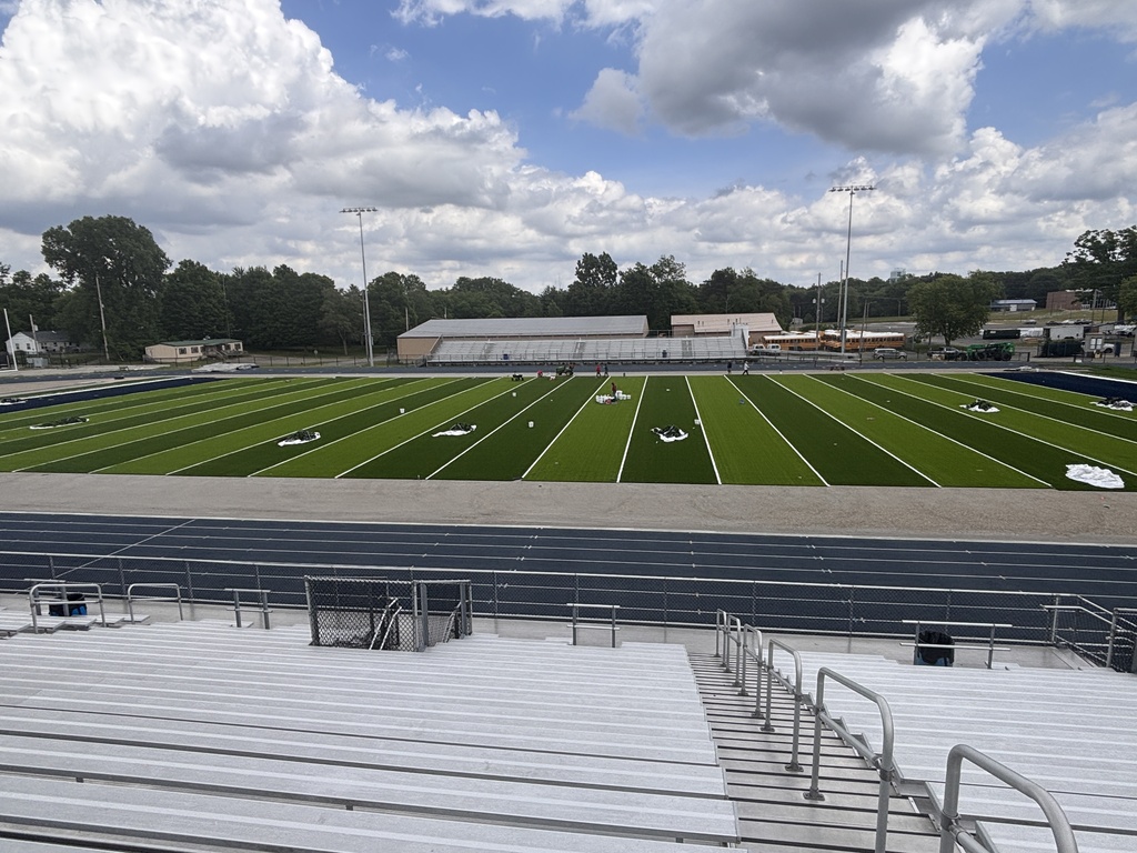 An aerial view of a football field that has bright, green artificial turf on it