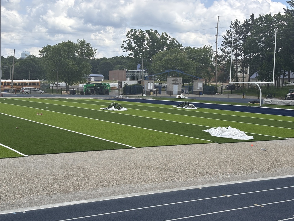 A view of a football field which has a new layer of artificial turf installed on it