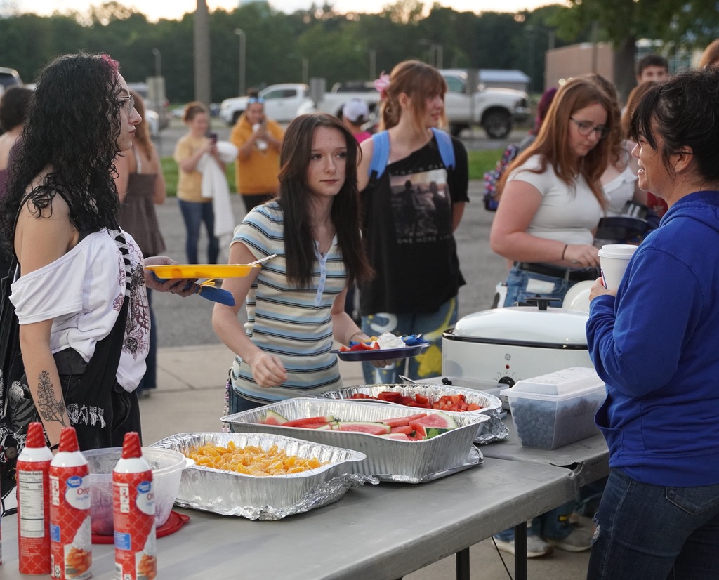 Two female students scoop breakfast on their plate from a buffet style line.