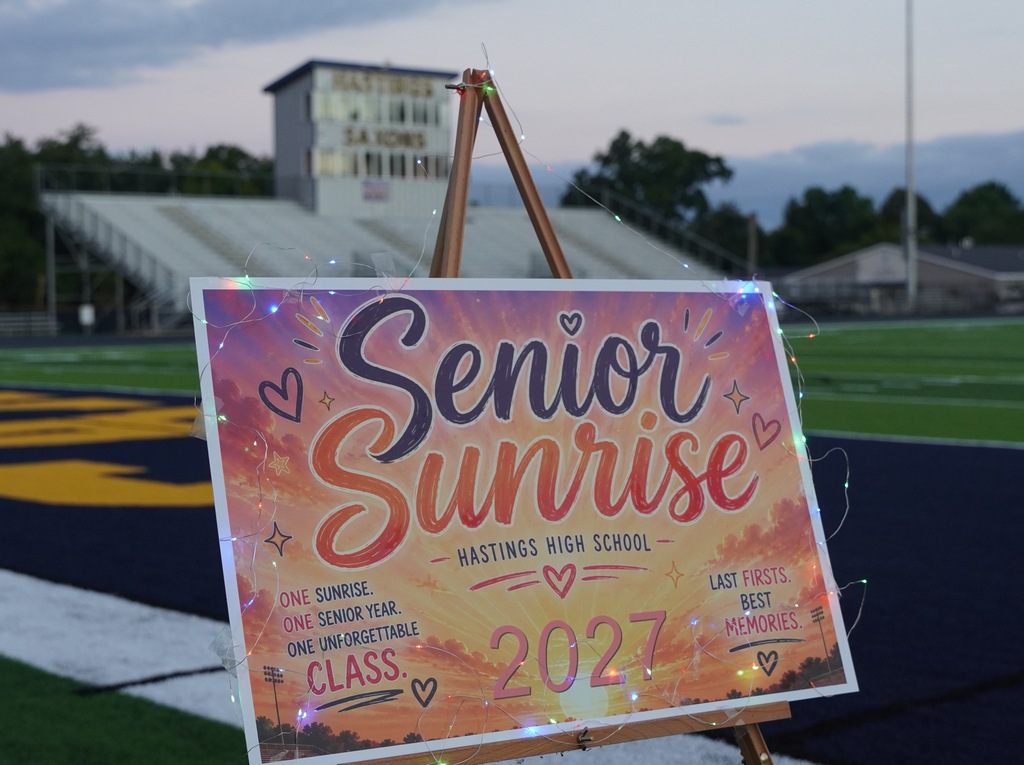 A sign that says "Senior Sunrise" is displayed on a large poster set on the football field.