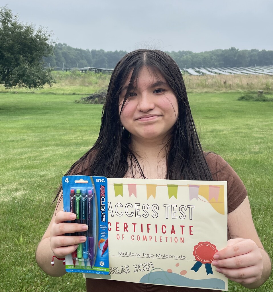 A girl holds a certificate that says "Access Test Certificat" on it