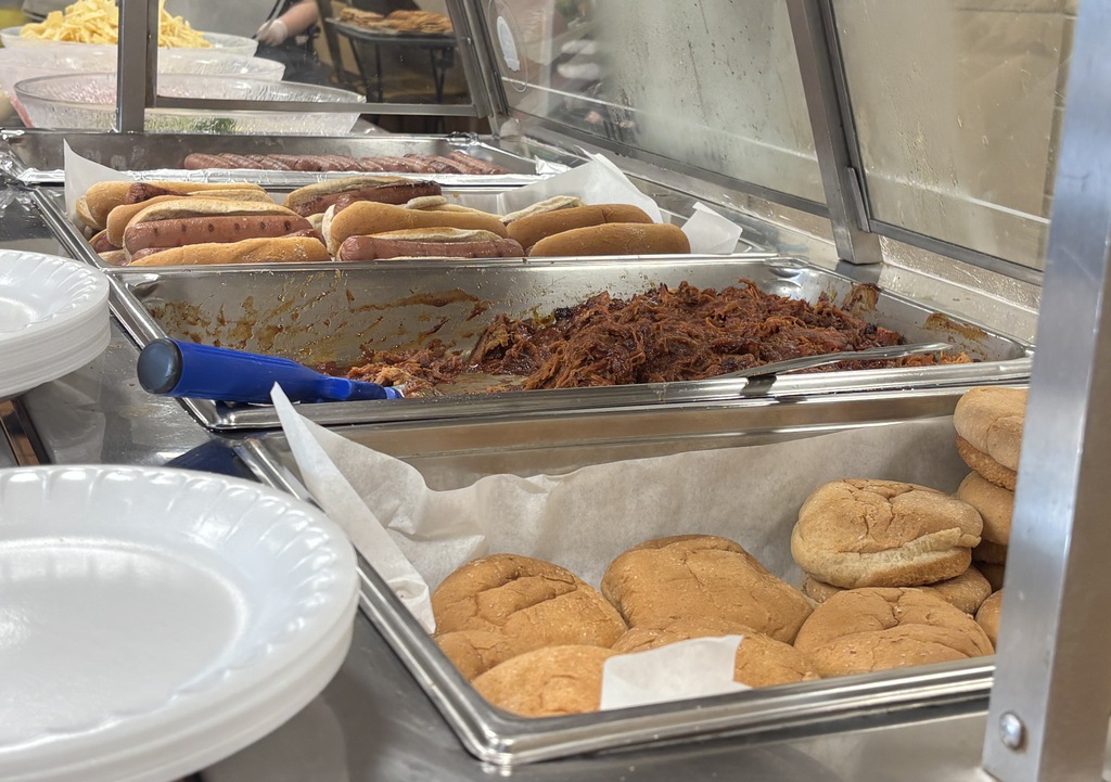 Piles of hot dogs, hamburger buns and pulled pork waiting to be served.