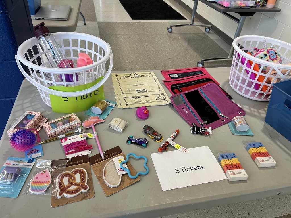 White baskets on a table holding items with other items scattered around them.