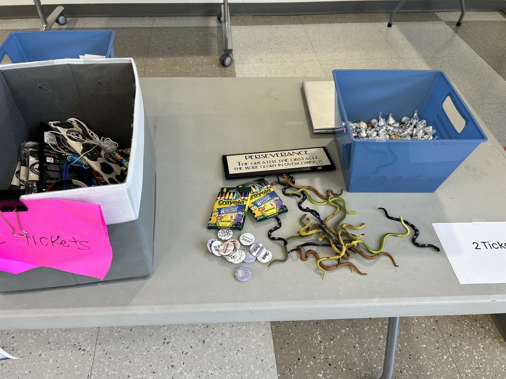Bins on a table holding stickers, candy and other items.