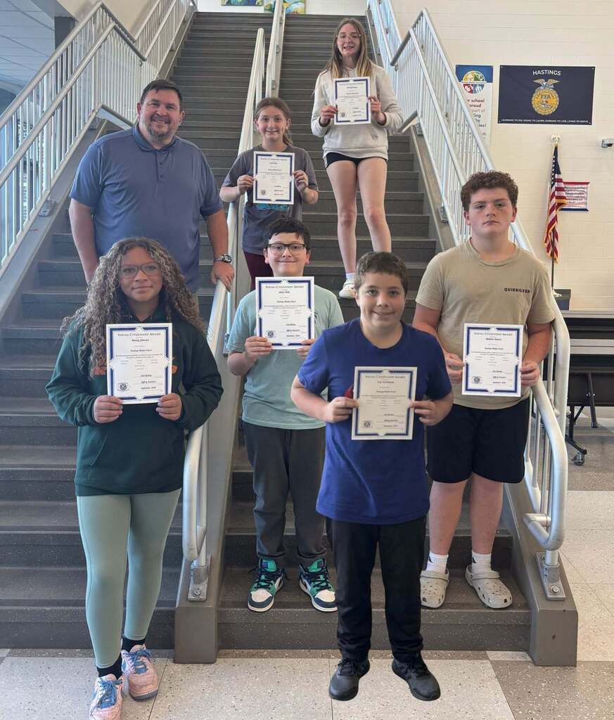 Kids pose while holding a certificate