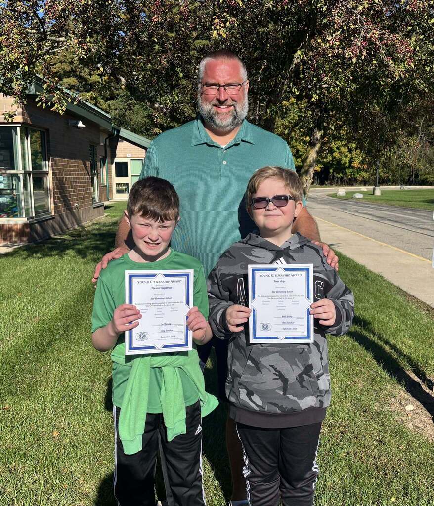 Kids pose while holding a certificate