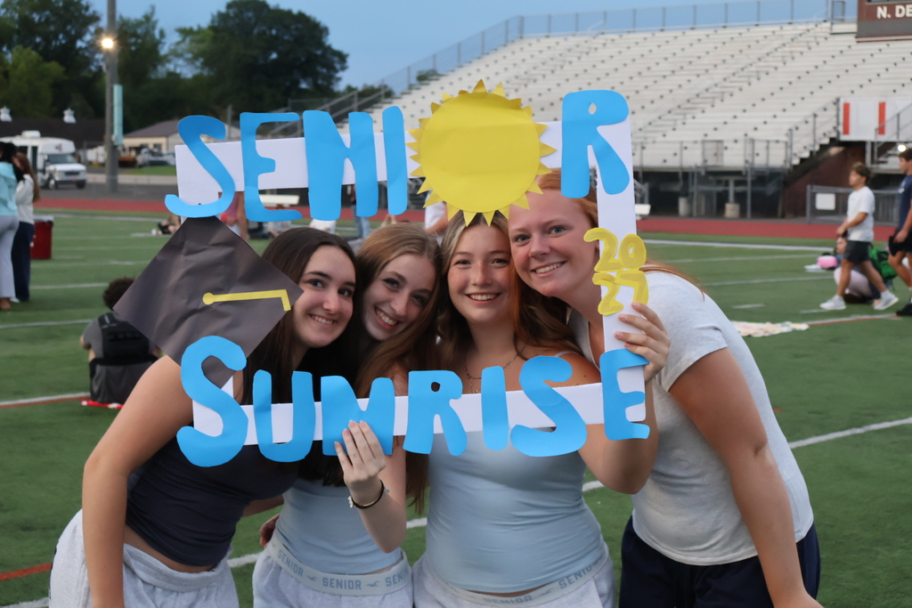 Students pose for photos with their Senior Sunrise cutouts