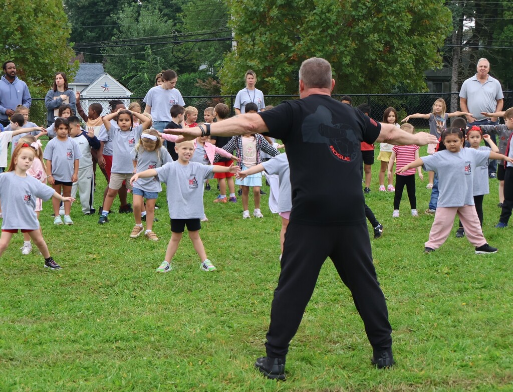 Fitness instructor teaches students how to stretch.