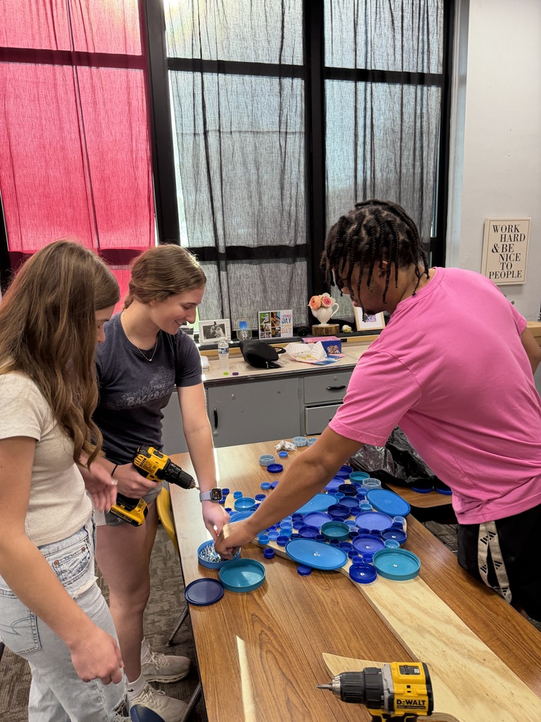 students adding bottle caps