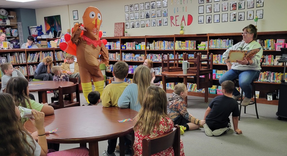 Mrs. Sands dressed as a turkey posing with students