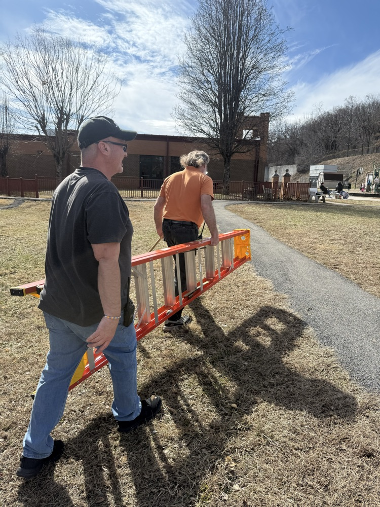 two men carrying a ladder