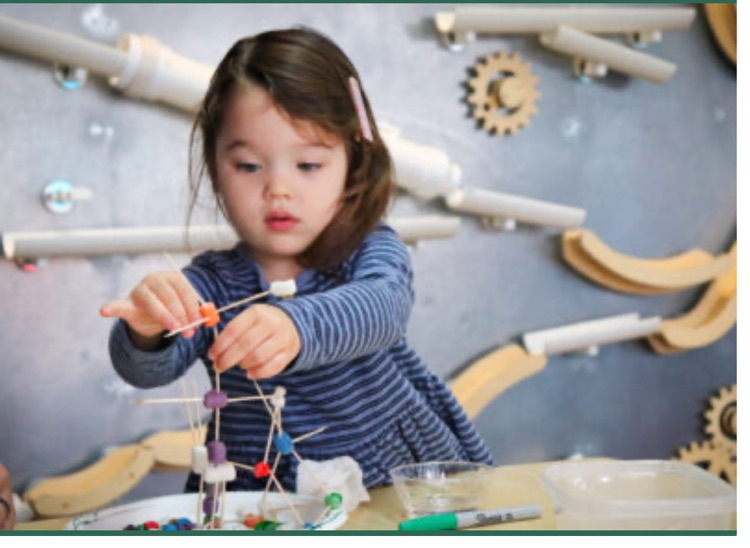 girl using toothpicks to build a structure