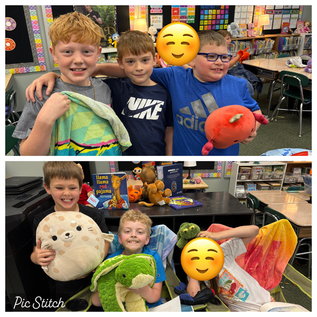 Four young boys in a classroom, two holding toys, one holding a blanket, and one holding a stuffed animal.
