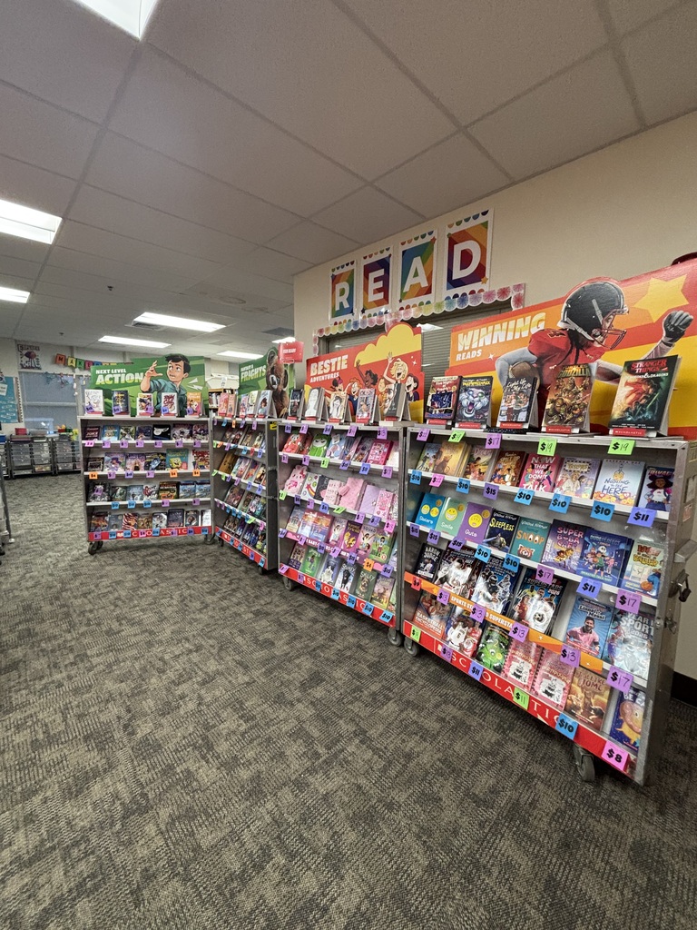 A store with multiple shelves full of books and a large "READ" banner on a wall.