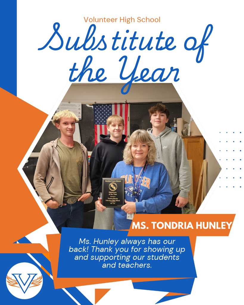Woman and students stand with an award. Behind them is an American flag and a wooden cabinet.