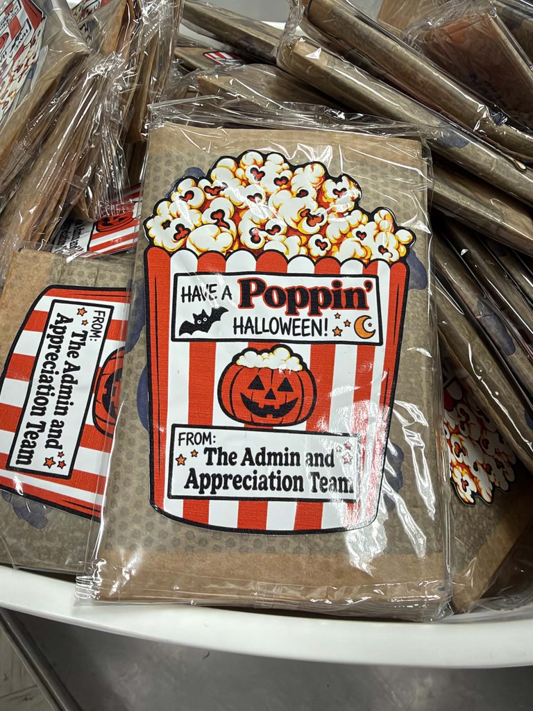 Plastic bags contain popcorn in a bucket-shaped bag with a Halloween theme, including a pumpkin face.