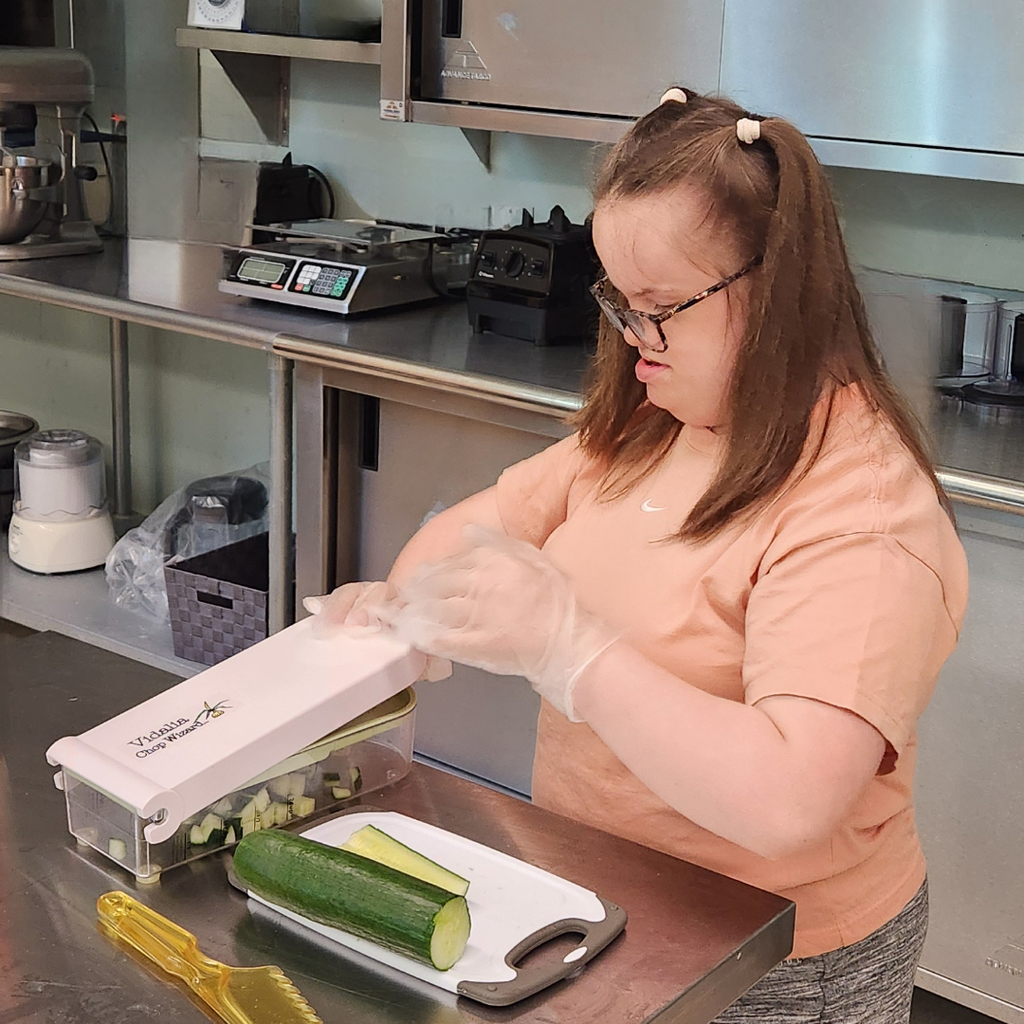 Student chopping cucumbers for Lunch Box salad