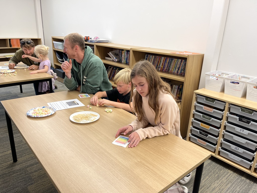 Parents with students doing an activity at tables