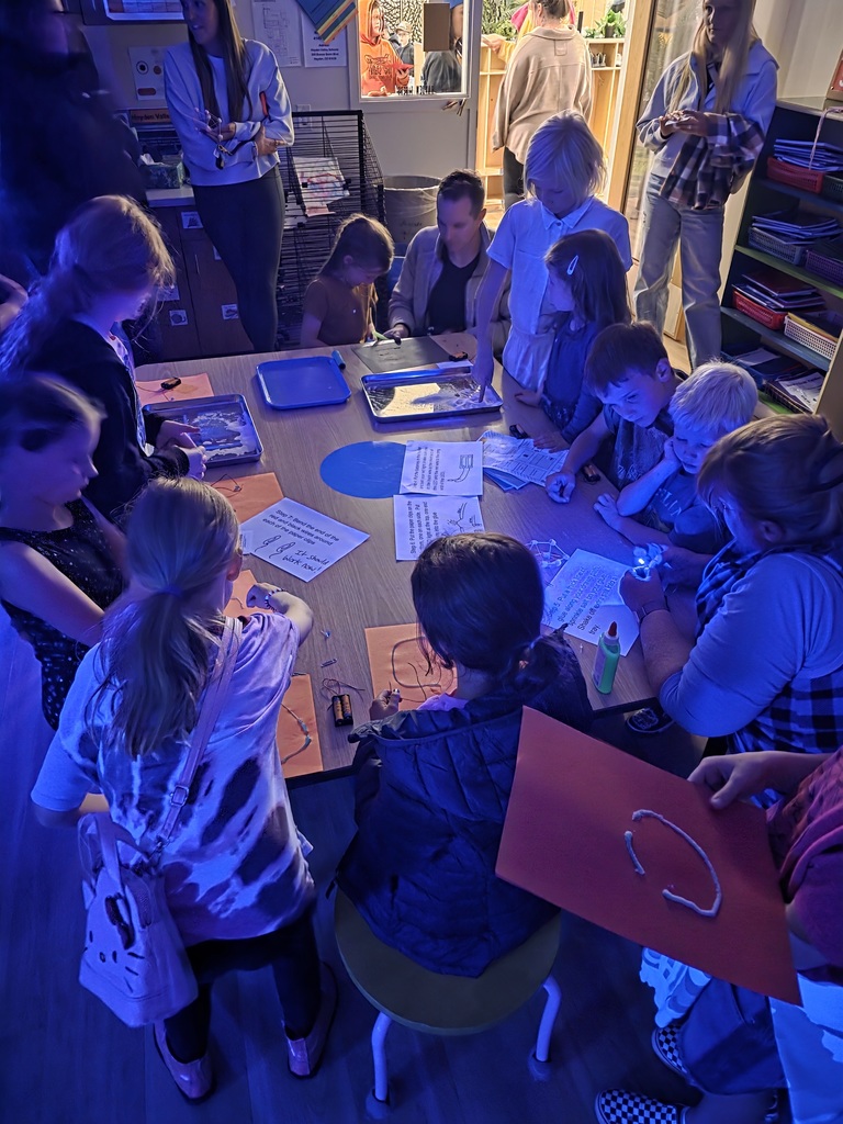 A glow activity with kids around the table with white lights