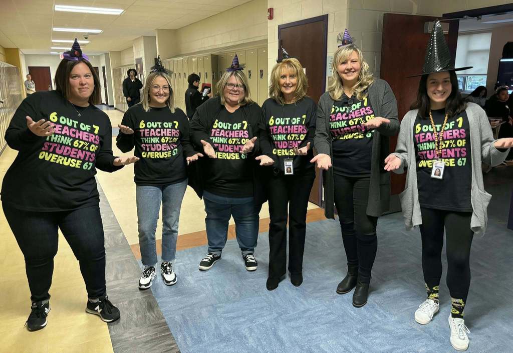 Teachers posing in the hall in matching Halloween shirts