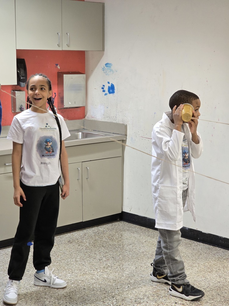 Kids learning about using cups and string to transmit sound