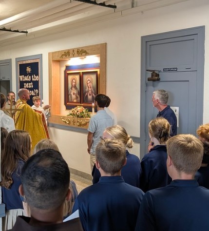Fr. Brian blesses the images that will hang in TMP-Marian's 2nd floor hallway