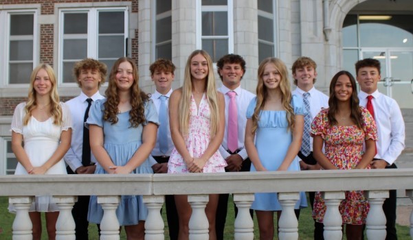 2025 Homecoming candidates posing in front of the TMP-Marian school building