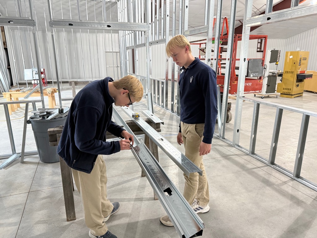Two  students work on the interior framing of the CTC on the campus of Thomas More Prep-Marian.