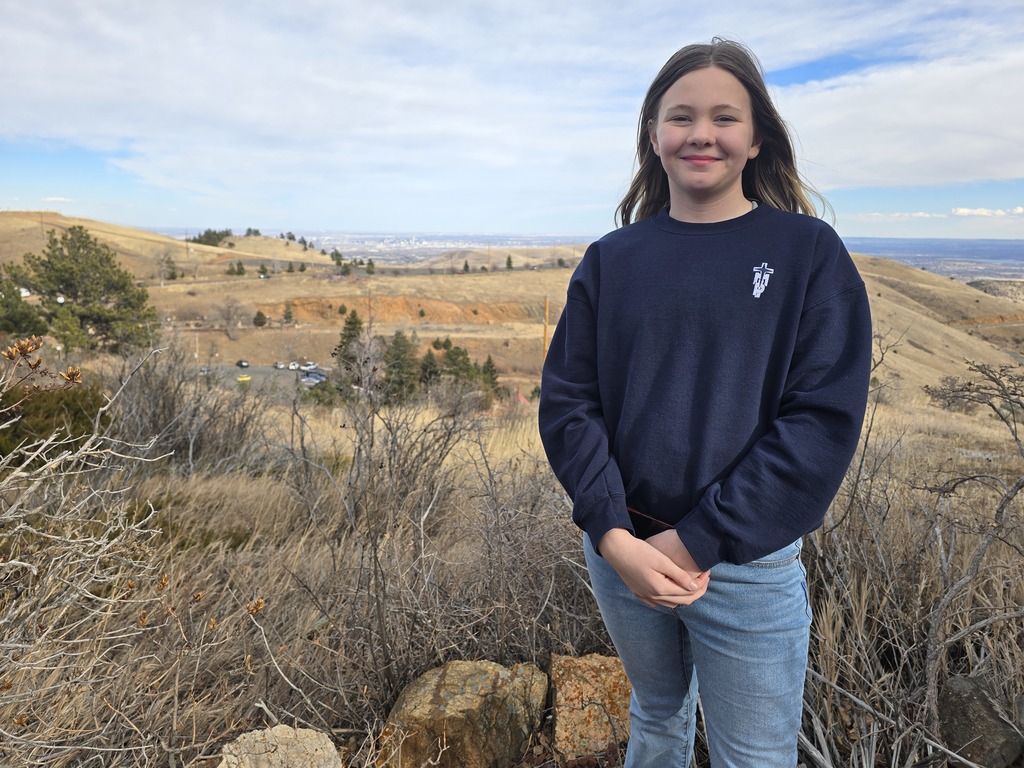 A female student in in the foreground of the foothills west of Denver.