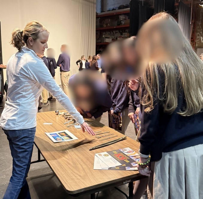 A woman in a white shirt explains medical photos to students