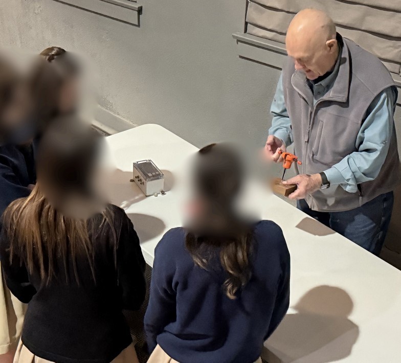 Students view a demonstration of an orange seismology tool.