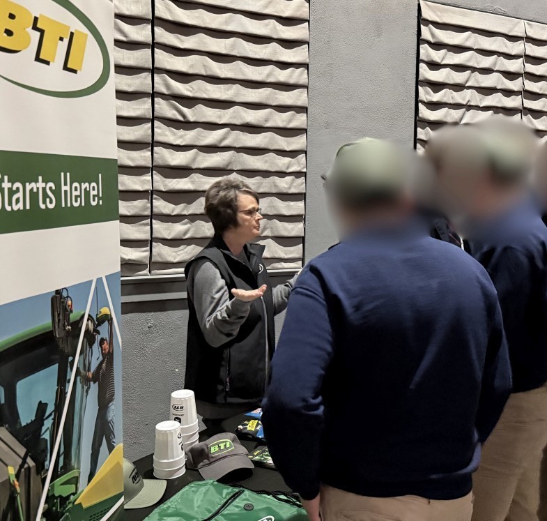 A woman in a black vest explains BTI information to students