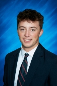 male student in a navy blazer with a tie