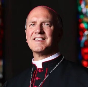 Bishop Vincke in black clerics with rose colored buttons