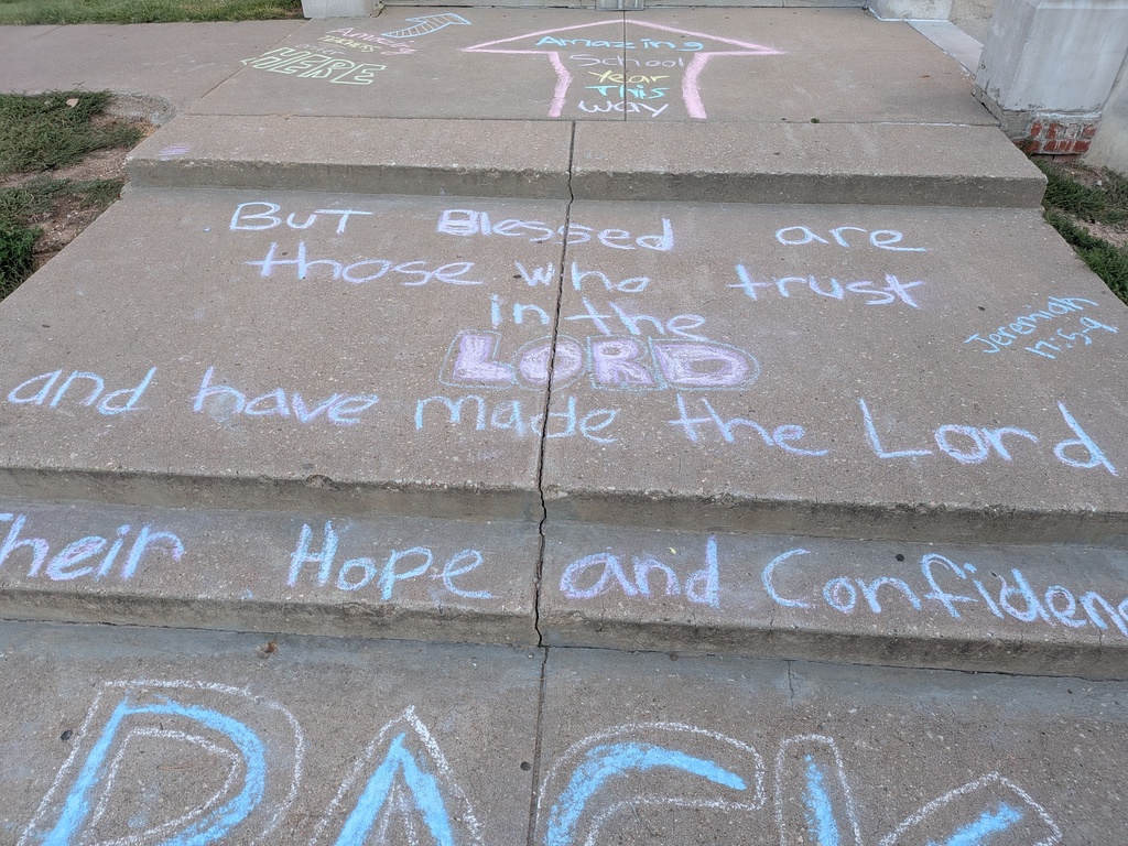 Blue chalk words on a sidewalk